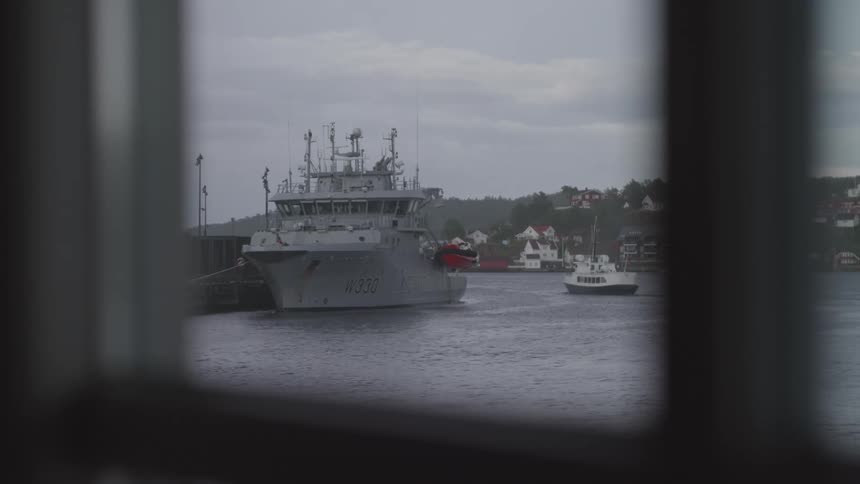 A military boat seen through a window of a house