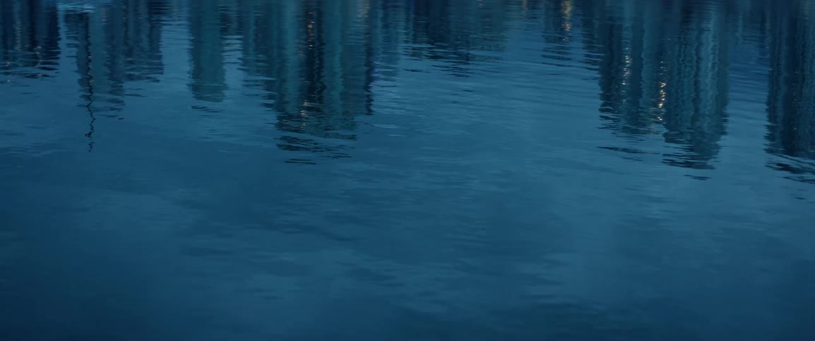 Calm ocean with reflection of buildings in a metropolis