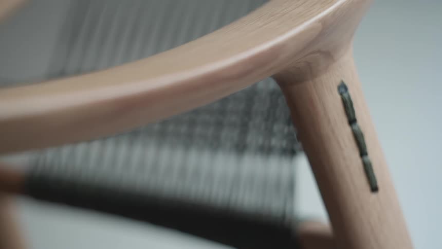 A wooden chair with a strip of fabric on one leg