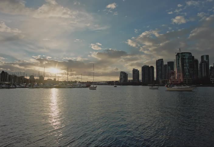 Sun shines on waterfront apartment buildings and nearby marina