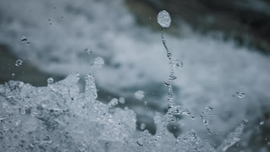 Flowing water from a river falling and splashing in slow motion