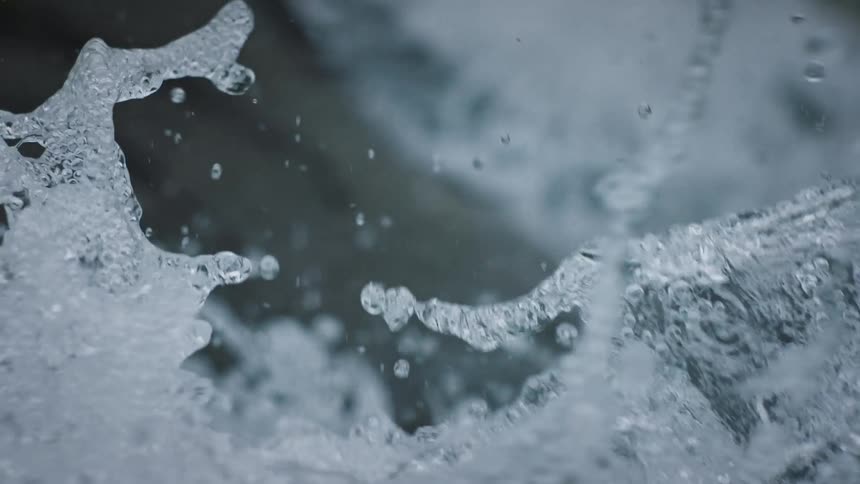 Splashes of flowing strong water from a falling river in slow motion