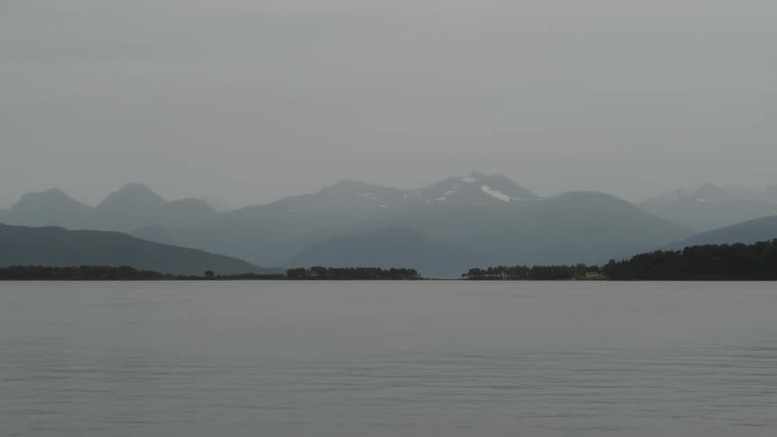 A huge bay of water with some islands on the horizon and huge mountains