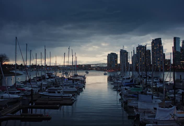 Panorama of boats and yachts in a marina under a moody evening sky