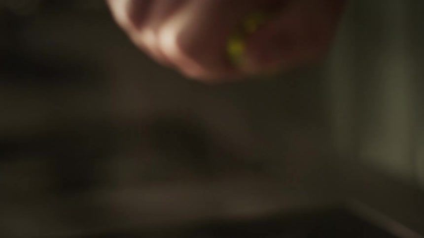 Chef removes cork from olive oil and uses thumb to control the drizzle over herbs in the pan
