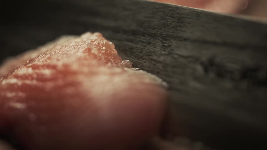 A person cuts fish with a knife