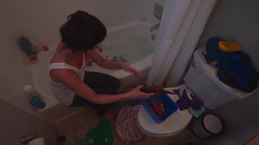 A clip of a girl washing her toys in the bathroom