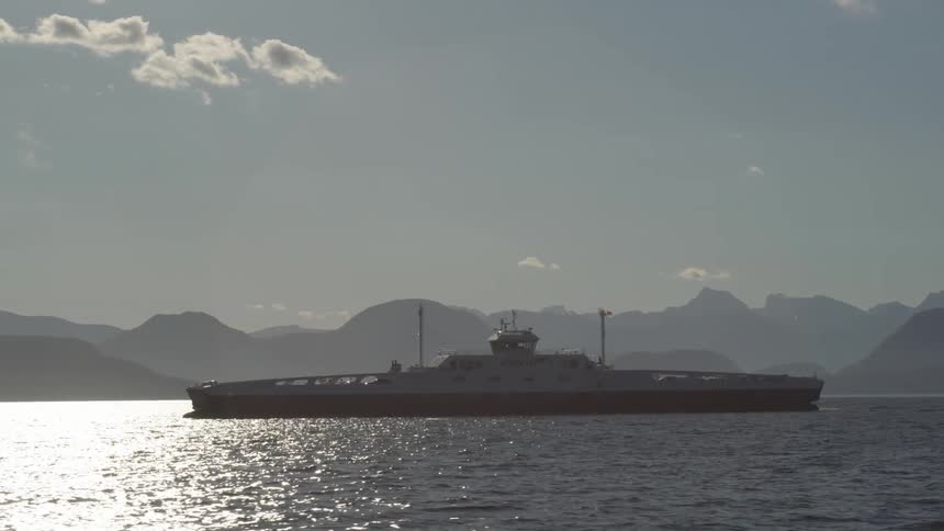 A wide shot of a ferry moving vehicles