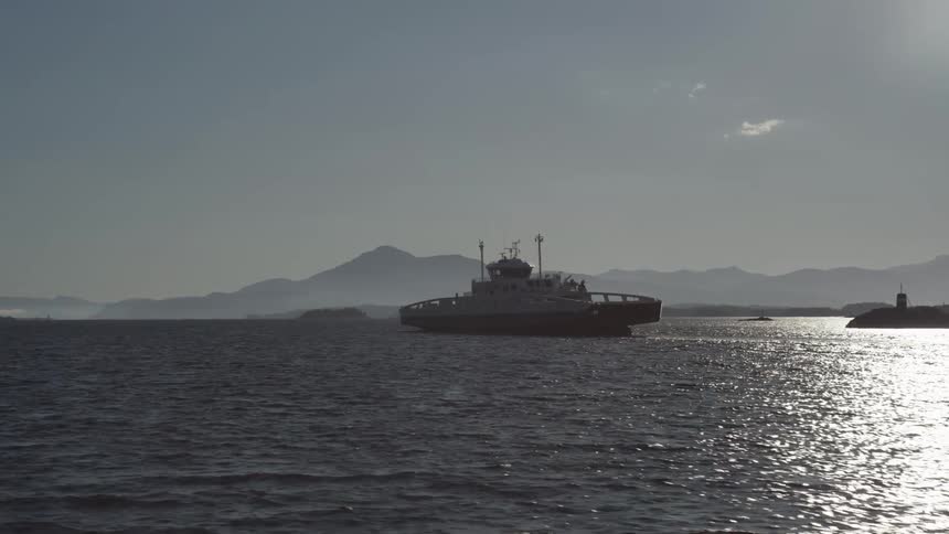 Mediumsized boat moving through the sea on a blue sky day with few clouds