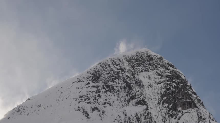 Snow blows along a mountain top