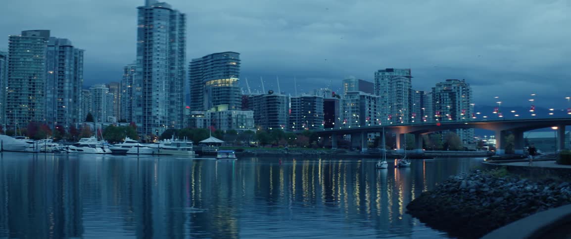A boat moving in front of Vancouver's Cambie Bridge at dawn