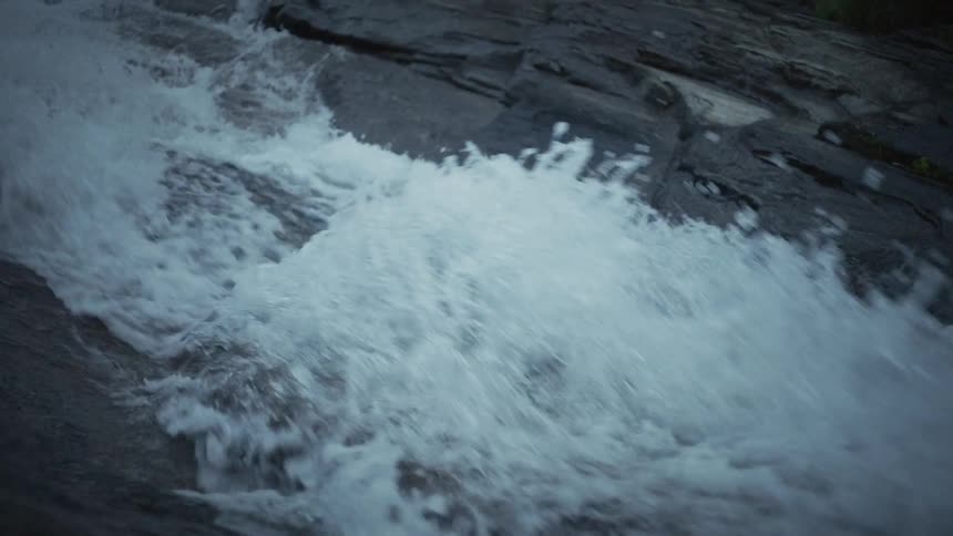 Strong flowing water of a river in a stone waterfall