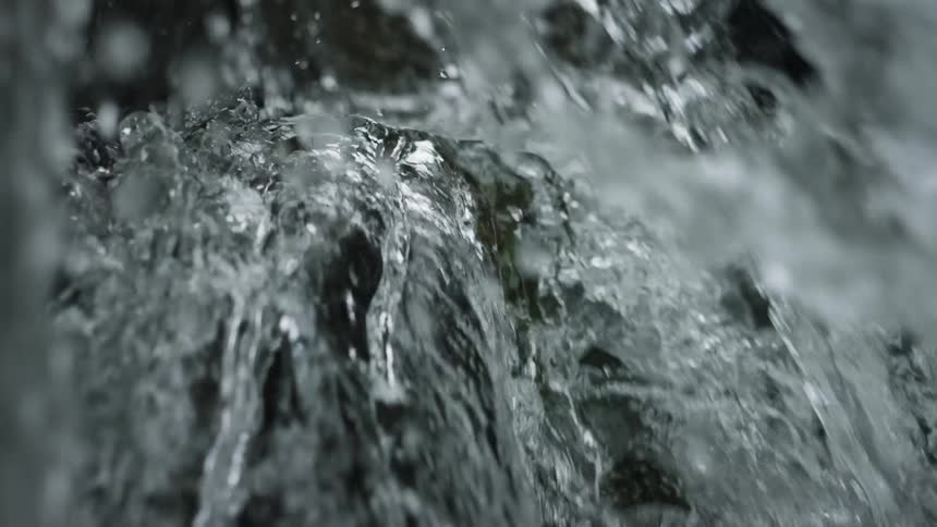 Close up of water rapidly flowing over rocks