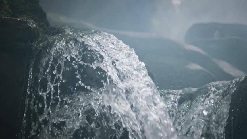 Water cascades down a rocky surface in the mist