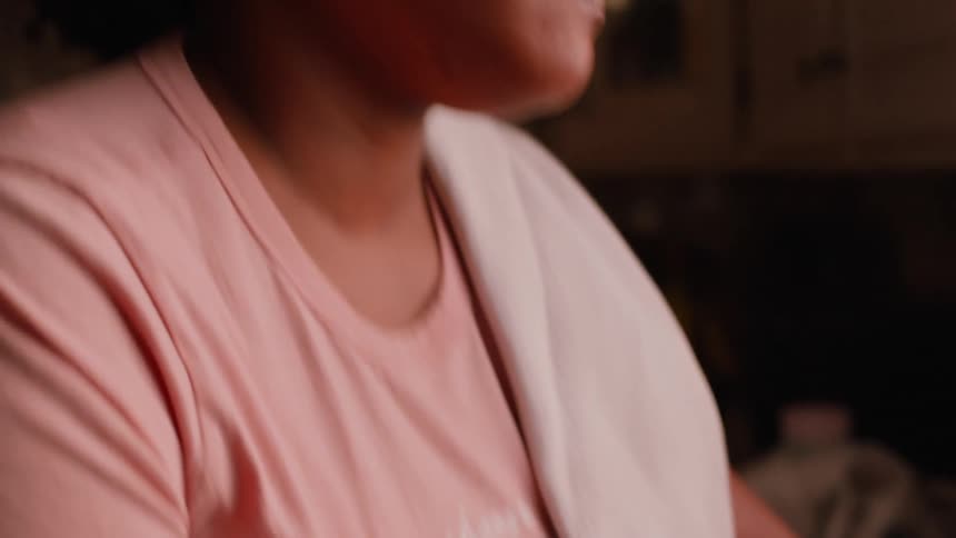 Side portrait of a woman washing a mug in the kitchen