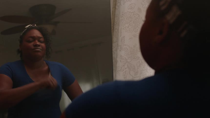 A clip of a lady changing her dress in front of a mirror