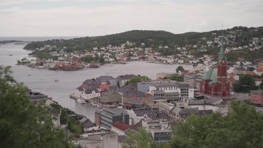 Panorama of an urban city by the sea and amid mountains on a cloudy day