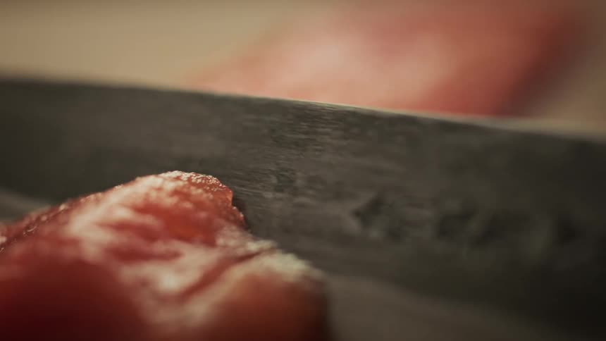 Special seal cutting a salmon on a wooden bench