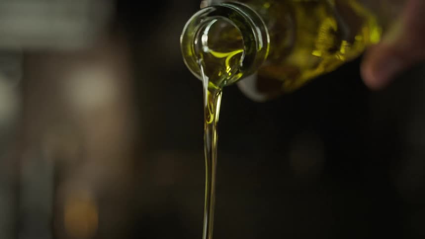 A man pours oil out of a bottle