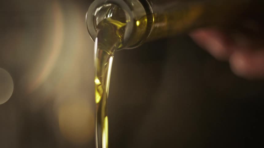 Oil is being poured into a pot
