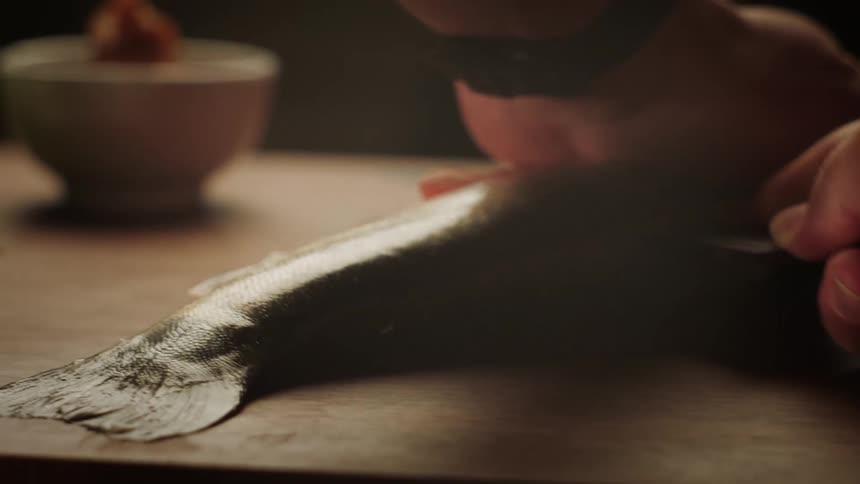 A clip of a person slicing a fish