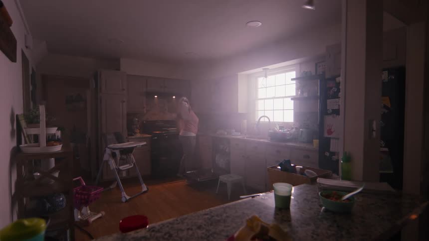 A woman waves a towel in a kitchen