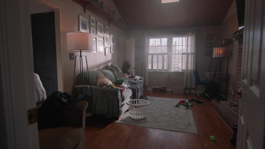 A woman is folding laundry on the couch
