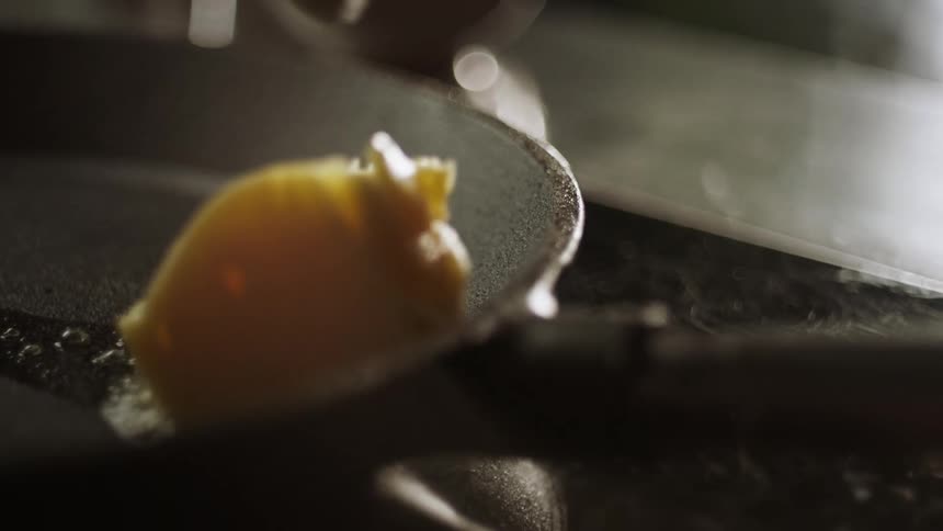A person melts butter in a pan