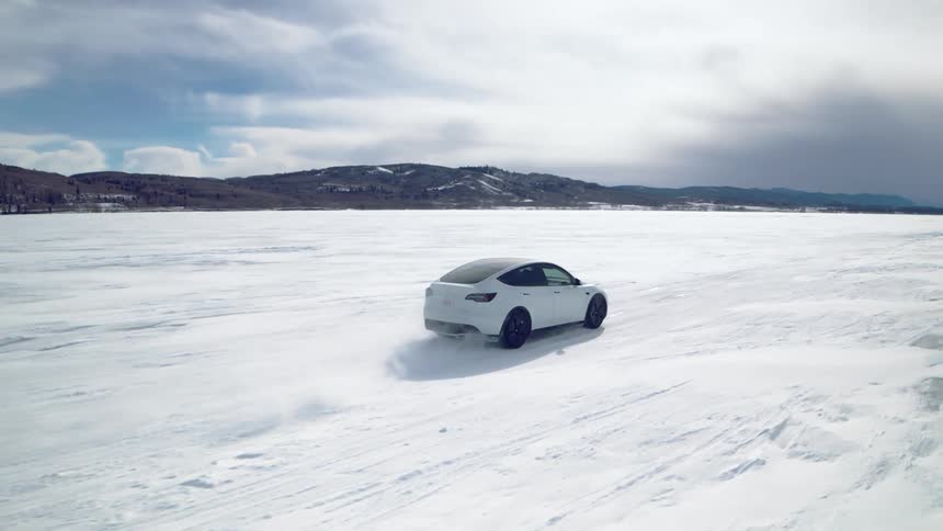 White sports car traveling on a frozen lake on a cloudy day