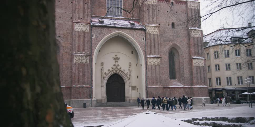 A group of people is walking towards the entrance of a cathedral