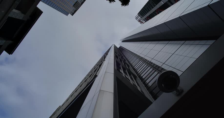 A huge building with mirror walls and a sky with white clouds