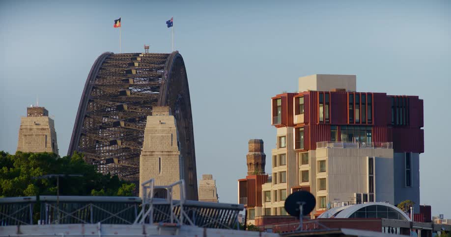 The sidney harbor bridge next to buildings
