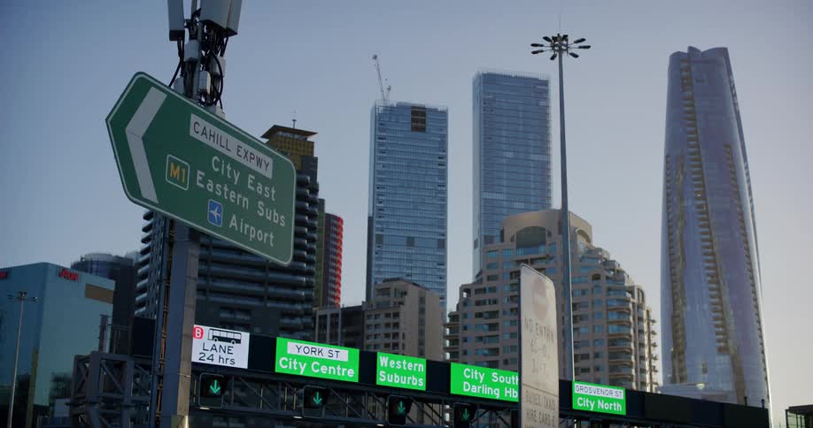 Signs and screens and skyscrapers in the background on a cloudless morning