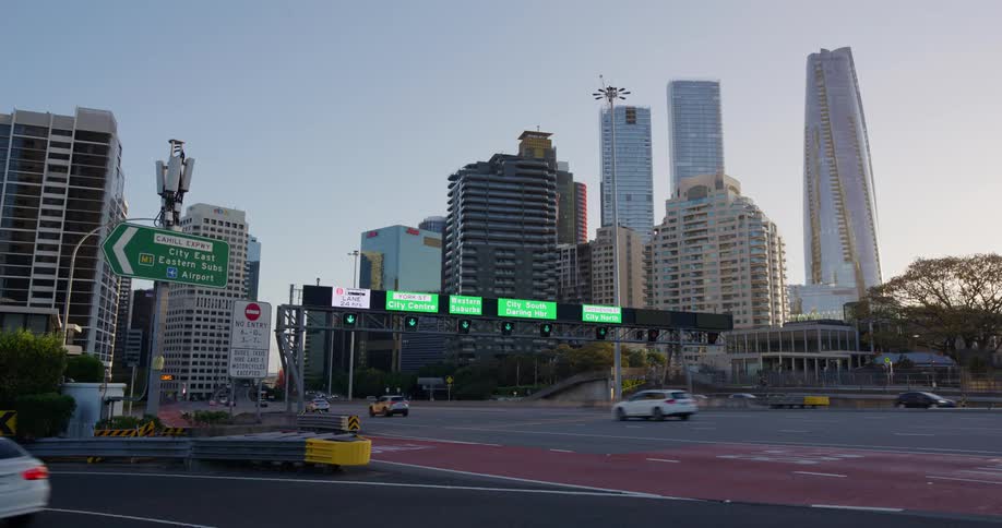 Vehicles trundle along a road in a city