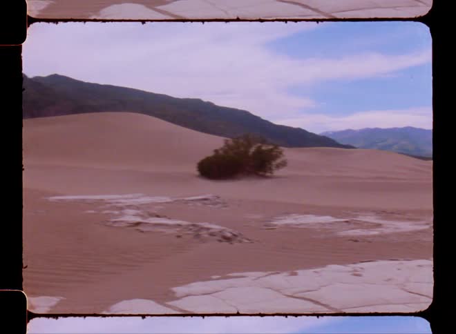 Landscape of a desert location with mountains around on a blue sky day with clouds