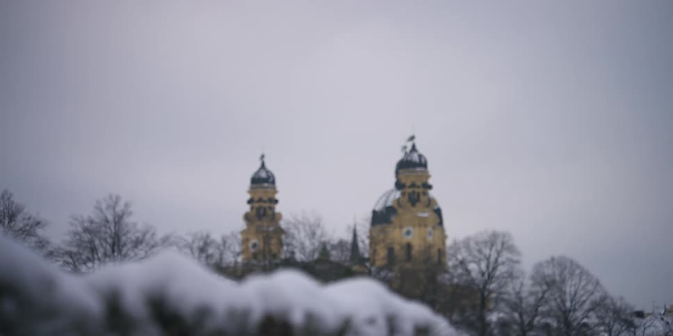 Snow on leaves and two towers in Munich