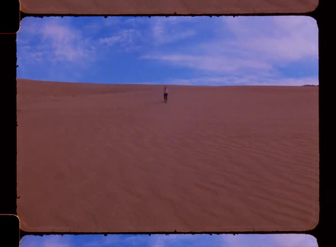 Person walking down a sandy slope in the desert