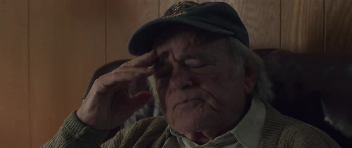 Portrait of an elderly man placing his hand on his face with a facial expression of crying and sadness