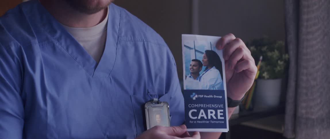 Doctor talking inside a room while presenting a pamphlet