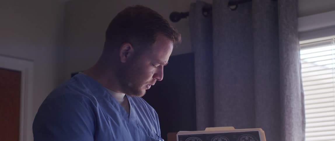 A medical worker explains a radiograph while standing in a hospital room