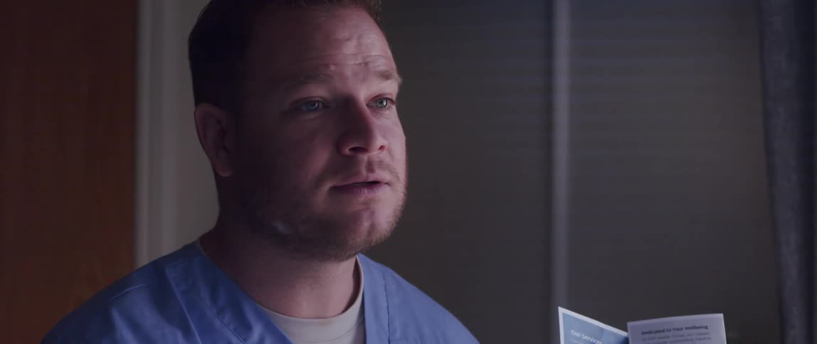 A doctor motions toward a pamphlet while talking to a patient