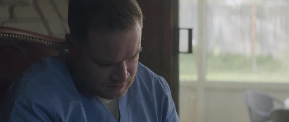 Male nurse sitting at home listening to a patient