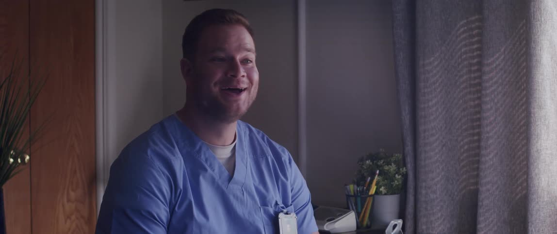 Nurse reviews information on clipboard and discusses it in a hospital room