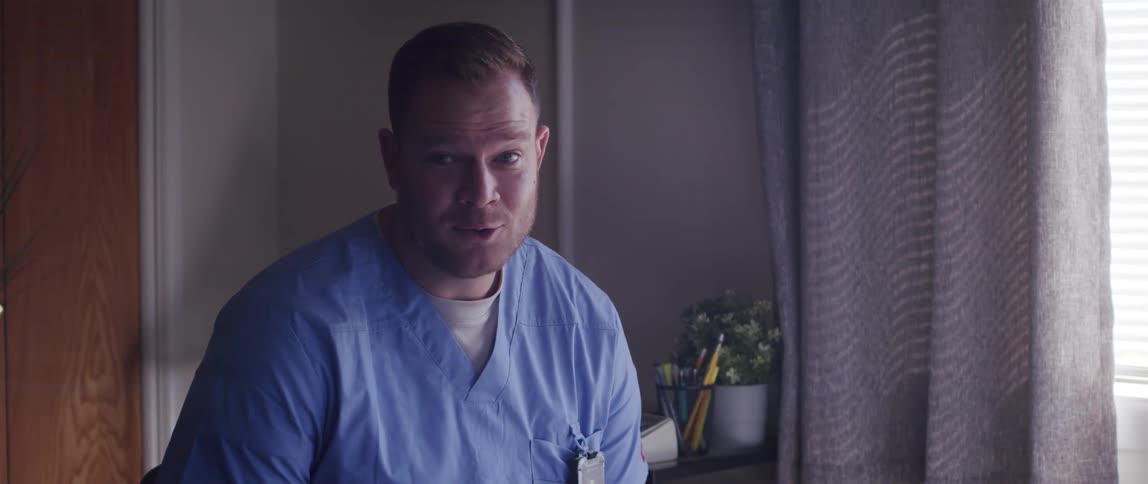Medical professional holding a clipboard sits and talks to patient