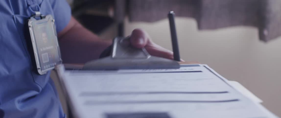 A person handling documents on a clipboard