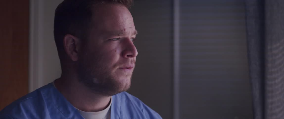 A male nurse sitting in a room talking