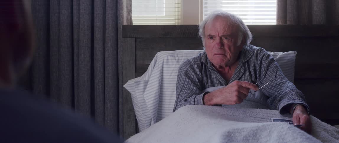 An elderly man resting in bed angrily arguing with someone
