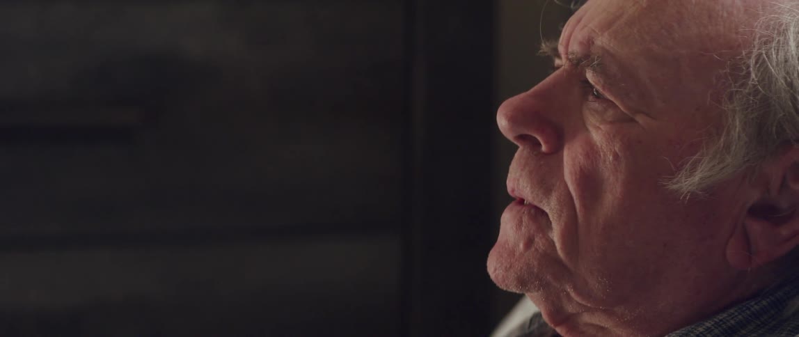 Side portrait of an elderly man talking with a worried facial expression