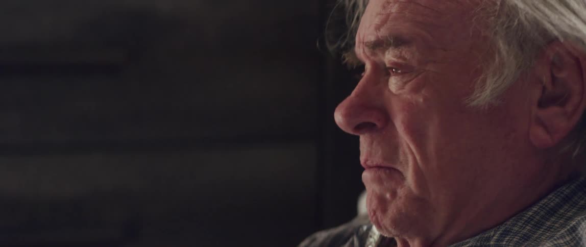 Side portrait of an elderly man bought blood and his eyes watering with sadness