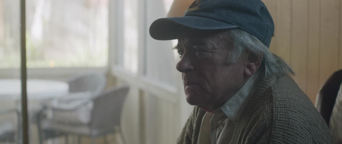 Elderly patient talking with sad facial expression to a doctor while both are sitting